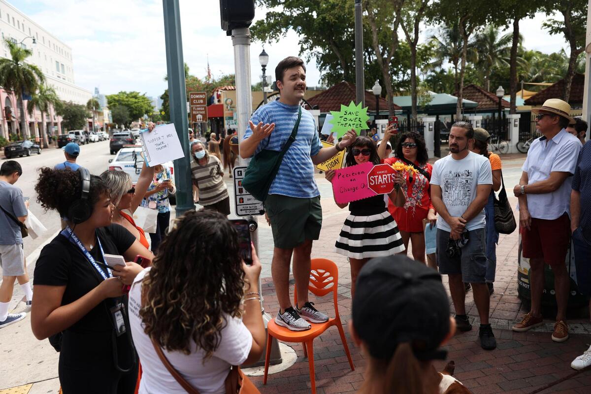 Chris Molina, local filmmaker, stands up to speak on a chair outside of the Tower Theater during the Miami Dade College Tower Theater protest on Tuesday, Oct. 4, 2022, in Little Havana.